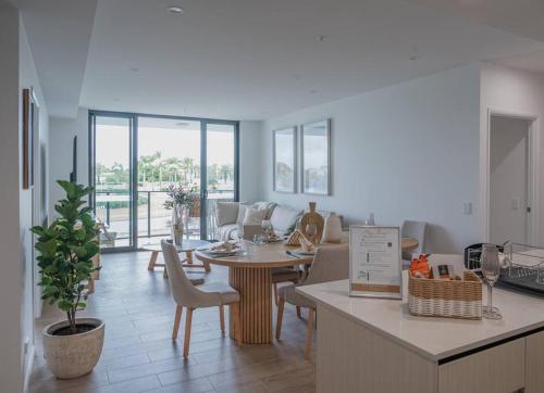 a kitchen and living room with a table and chairs at Lux Lakeside Apt - Gold Coast in Gold Coast