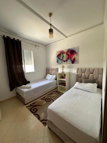a bedroom with two beds and a window at Appartement Tanger in Tangier