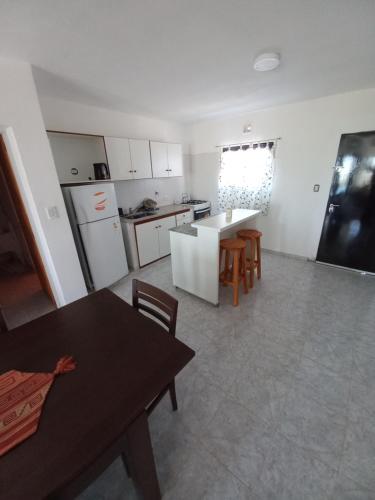 a kitchen with white cabinets and a table and chairs at Lo de Vicente in Pergamino