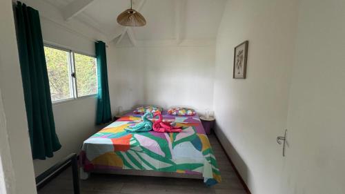 a bedroom with a bed with a colorful comforter at Moemiti in Moorea
