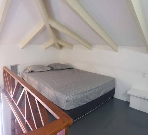 Posto letto in una camera bianca con scala. di Cozy apartment a Willemstad