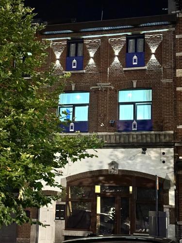a building with blue windows on the side of it at Sofieflat - Wallifolie in Charleroi