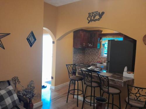 a kitchen with a bar with stools in a room at Blair's Vacay Home in Albert Arms