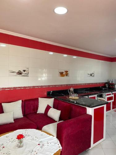 a living room with a red couch and a table at villa victoria in Tetouan