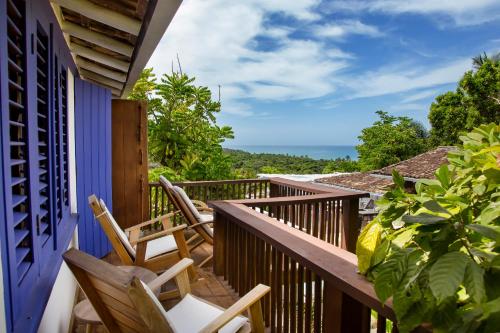a balcony with chairs and a view of the ocean at Pousada El Gordo in Trancoso