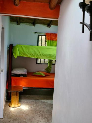 a bedroom with a bunk bed with a green canopy at EL RETORNO in Marinilla