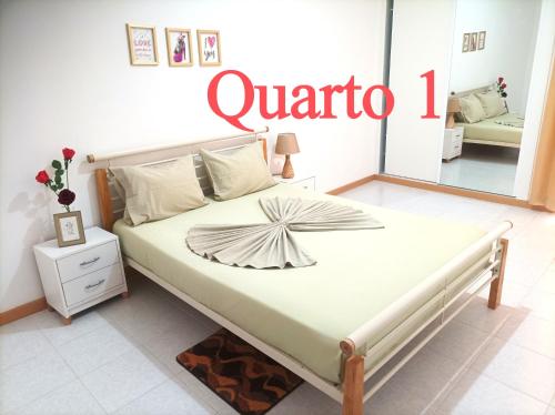 a bedroom with a bed with a sign that reads quaria at Casa do Encanto in Praia