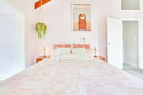 a bedroom with a large bed with white walls at LakeSide Tinaroo only 2.5km from Yungaburra town in Yungaburra