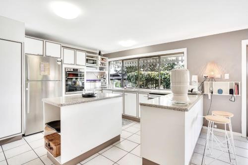 a kitchen with white cabinets and white appliances at LakeSide Tinaroo only 2.5km from Yungaburra town in Yungaburra