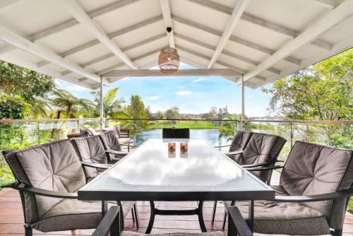 a patio with a table and chairs on a deck at LakeSide Tinaroo only 2.5km from Yungaburra town in Yungaburra