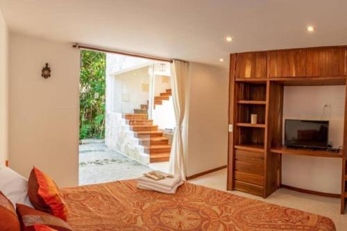 a bedroom with a bed and a sliding glass door at Villa Yaakun in Tulum