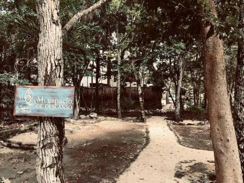 a sign attached to a tree in a park at Villa Yaakun in Tulum
