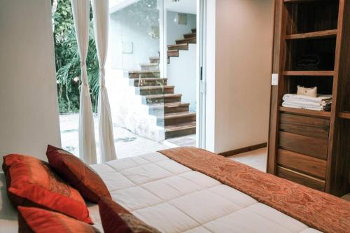 a bedroom with a bed and a stair case at Villa Yaakun in Tulum