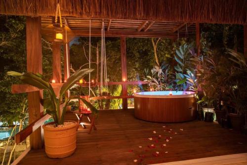a hot tub sitting on a wooden deck with plants at Villa Yaakun in Tulum