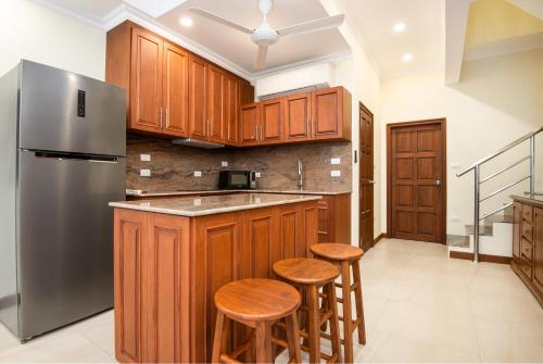 a kitchen with wooden cabinets and a stainless steel refrigerator at Pratamnak Residence Luxury Villas in Pattaya South
