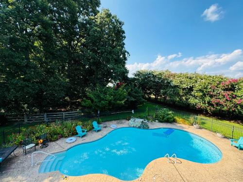 an overhead view of a swimming pool with chairs and trees at Countryside Carriage House with Pool in Commerce