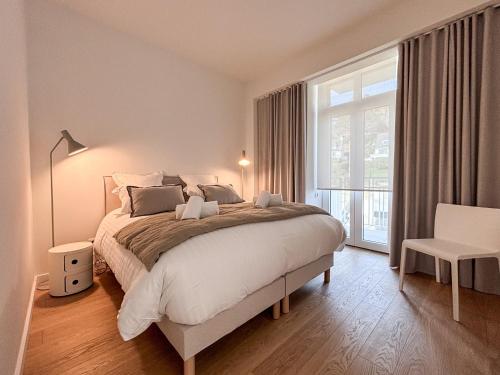 une chambre avec un grand lit et une grande fenêtre dans l'établissement le taureau - T3, à Trébeurden