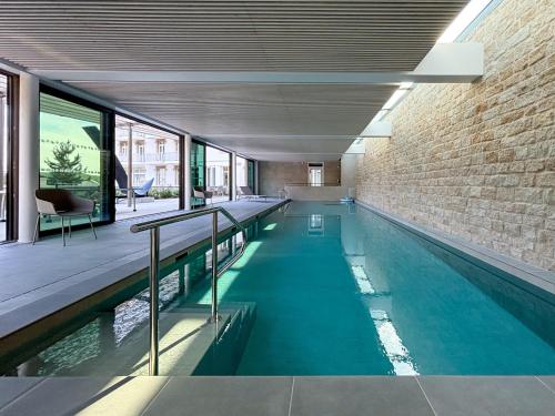 - une piscine intérieure dans un bâtiment avec un mur en briques dans l'établissement le taureau - T3, à Trébeurden