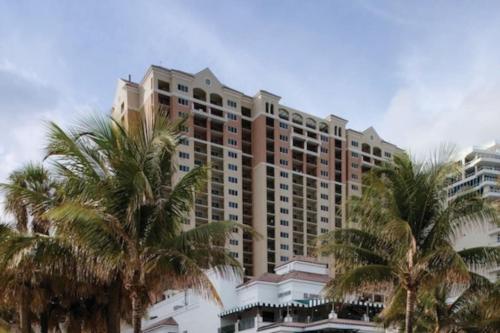 a large building with palm trees in front of it at Marriott BeachPlace Towers Luxury Guest Room in Fort Lauderdale