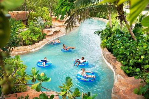 a group of people tubing down a lazy river at a theme park at Beautiful resort 1BD condo with amazing resort amenities pool, kiddie pool, and more in Nassau