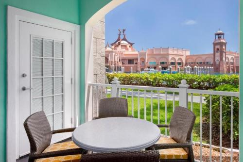 a patio with a table and chairs on a balcony at Beautiful resort 1BD condo with amazing resort amenities pool, kiddie pool, and more in Nassau