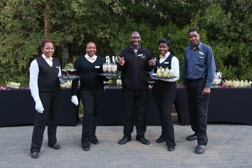 a group of people standing in front of a table with cakes at Misty Hills Country Hotel, Conference Centre & Spa in Muldersdrift