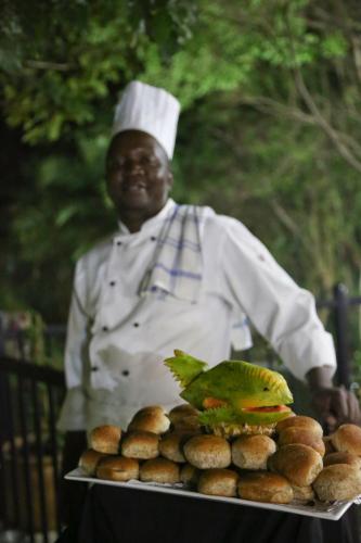 a man in a chefs hat holding a tray of food at Misty Hills Country Hotel, Conference Centre & Spa in Muldersdrift