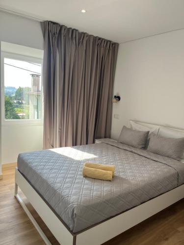 a bed in a bedroom with a large window at Guest House Kaka in Maia
