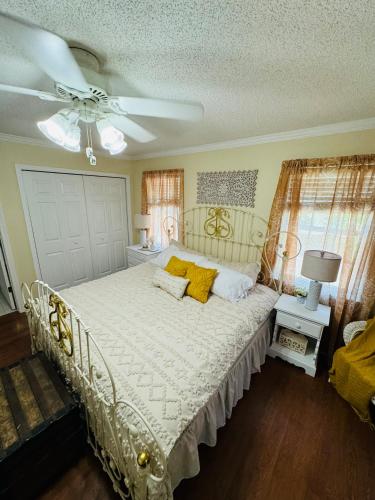 a bedroom with a white bed with yellow pillows at Countryside Carriage House with Pool in Commerce