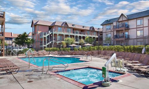 a large apartment complex with a swimming pool and chairs at WorldMark Solvang - 1BD Sleeps up to 4 in Solvang