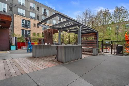a patio with an outdoor kitchen in front of a building at CozySuites Mill District with pool, gym # 09 in Minneapolis