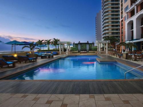 a large swimming pool with tables and chairs and a building at Marriott BeachPlace Towers 1BD in Fort Lauderdale