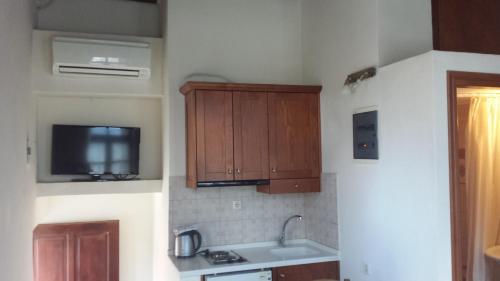 una cocina con armarios de madera y fregadero en Atelier, en Rethymno
