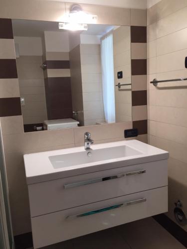 a bathroom with a white sink and a mirror at Appartamento Clelia in Pellizzano