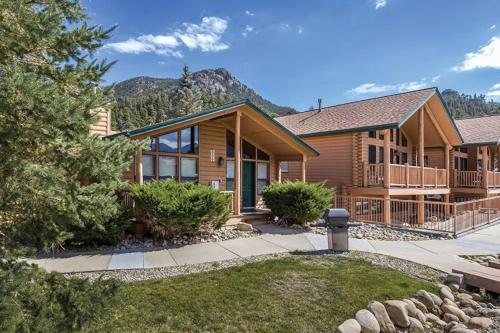 a log home with a mountain in the background at Worldmark - Estes Park 2BD in Estes Park