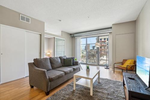 a living room with a couch and a table at CozySuites Mill District with gym #11 in Minneapolis