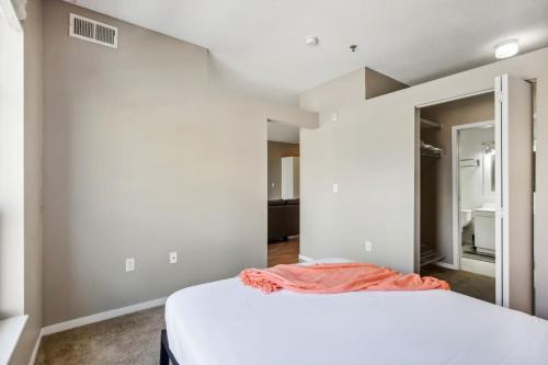 a bedroom with a white bed and a mirror at CozySuites Mill District with gym #11 in Minneapolis