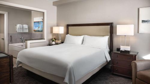 1 dormitorio con 1 cama blanca grande y bañera en Marriott Mountainside Luxury 1BD, en Park City