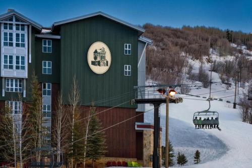 a green building with a ski lift in the snow at Marriott Mountainside Luxury 1BD in Park City