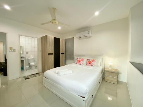 a white bedroom with a bed and a bathroom at Chalong - 2 Bedroom Hideaway Private Pool Villa - Phuket in Chalong 