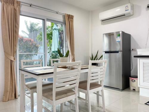 a kitchen with a table and chairs and a refrigerator at Chalong - 2 Bedroom Hideaway Private Pool Villa - Phuket in Chalong 