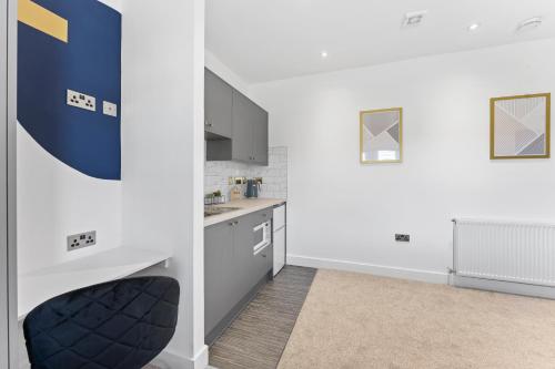 a kitchen with white walls and a black chair in a room at Westland House En-suite Whole in Peterborough