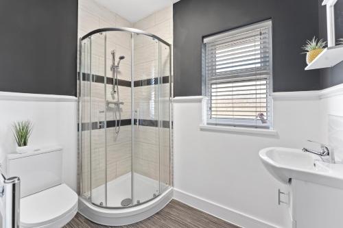 a bathroom with a shower and a toilet and a sink at Westland House En-suite Whole in Peterborough