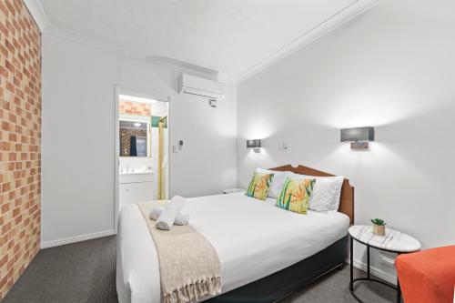 una camera da letto con un letto e una sedia in una stanza di Airport Clayfield Motel a Brisbane