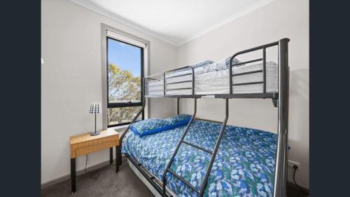 マウント・ブラーにあるPeak 203 A & B - Twin Key Apartments - Mt Bullerのベッドルーム1室(二段ベッド1組、デスク、窓付)が備わります。