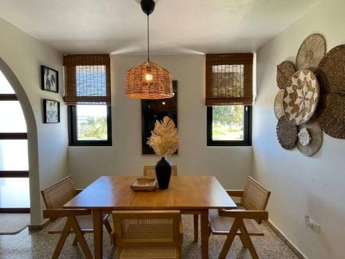 a dining room table with chairs and a vase on it at Casa Valentina Dreamy Beach Lakeview House in Punta Santiago