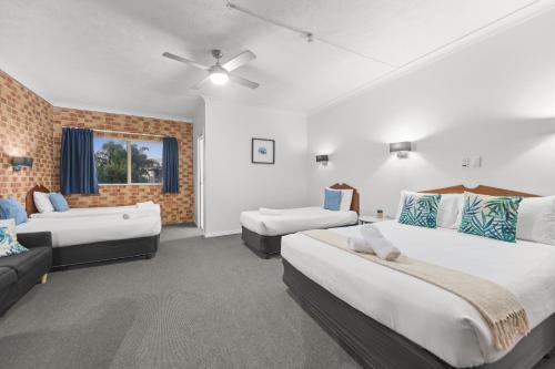 una grande camera con due letti e un divano di Airport Clayfield Motel a Brisbane