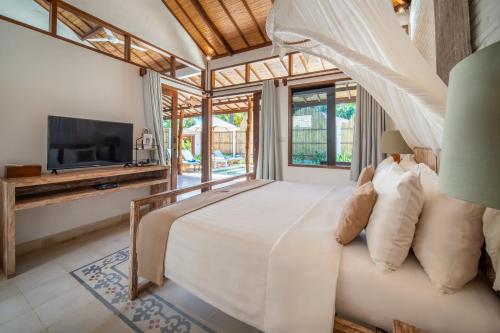 a bedroom in a villa with a bed and a tv at Wilson's Retreat in Gili Trawangan