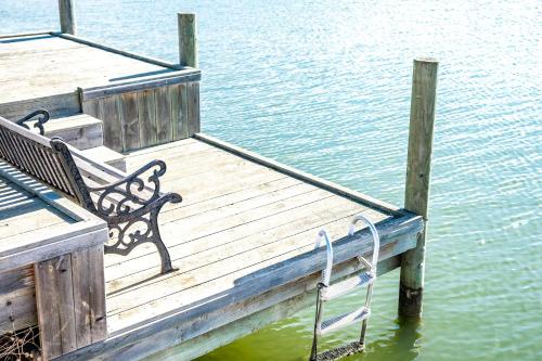 a wooden dock with a bench sitting on the water at 32 Blanche Pde Hindmarsh Island - No Linen Included in Hindmarsh Island