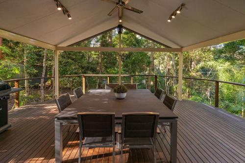 a wooden deck with a table and chairs on it at Allawah at Smiths Lake in Smiths Lake
